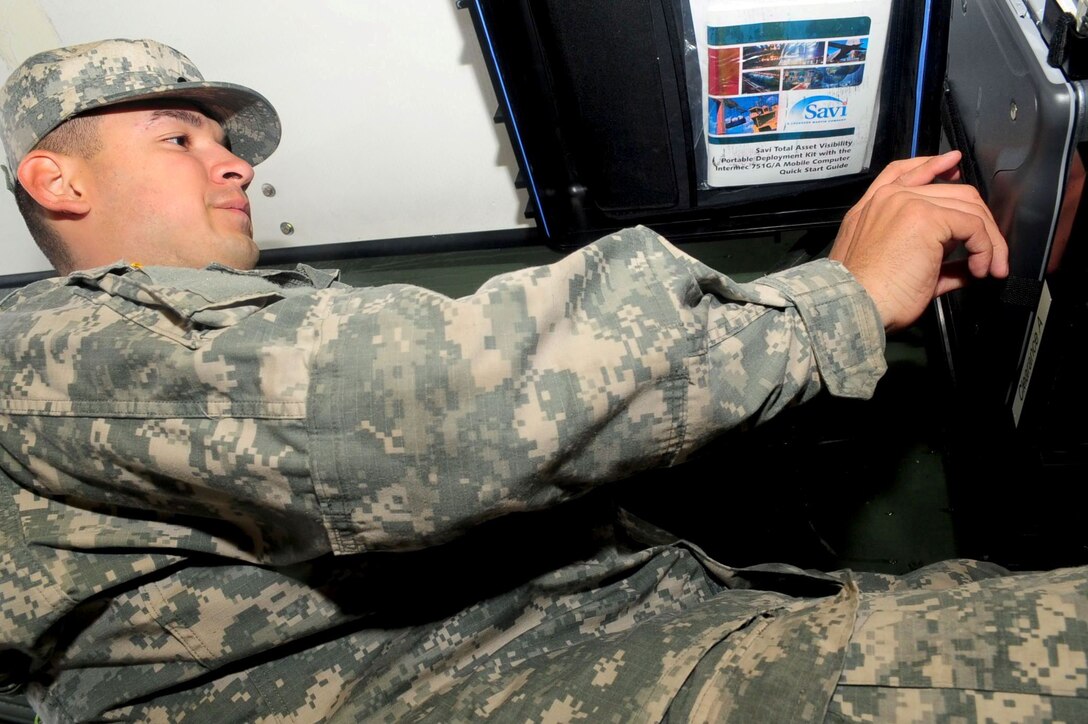 Spc. Francisco Espino, 690th Rapid Port Opening Element transportation manager and coordinator, opens a portable deployment kit. (U.S. Air Force photo by Staff Sgt. Ashley Hawkins/Released)