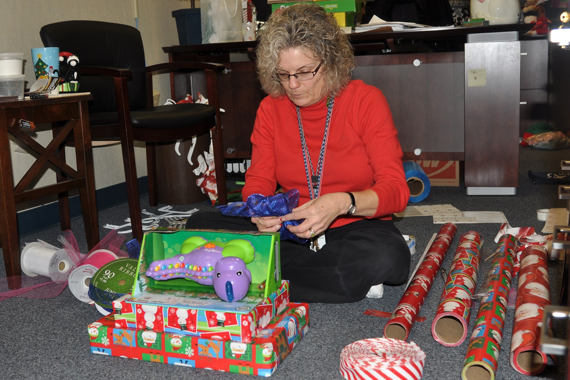 Taryn Montgomery, the financial management comptroller for the 307th Bomb Wing, wraps presents for the Santas in Blue program at the headquarters building on Barksdale Air Force Base, La., Dec. 14, 2011. The program is an annual event for Barksdale Airmen, and helps local foster care children celebrate the holiday season. (U.S. Air Force photo by Betty Stephens/Released)    
