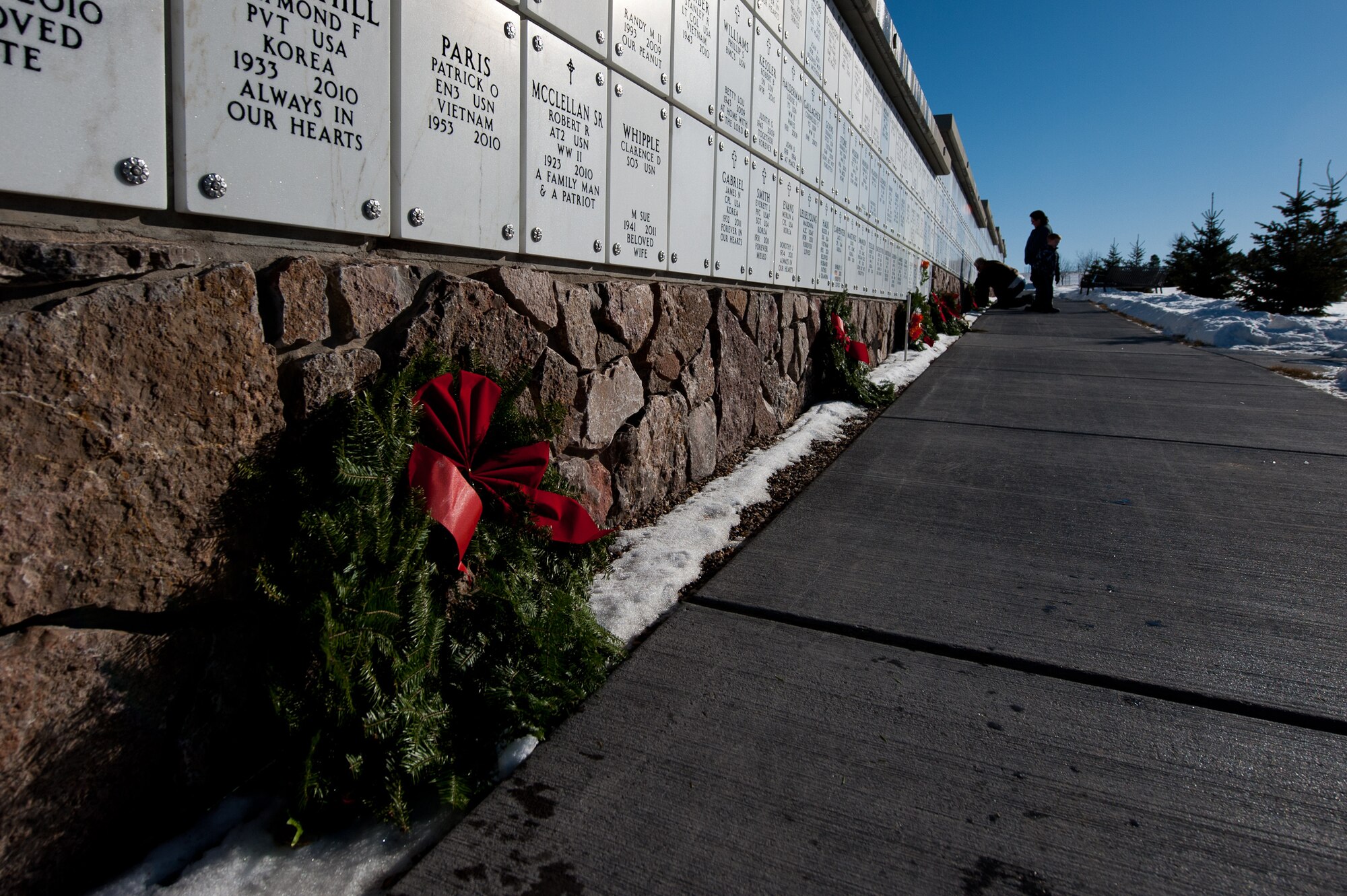 A Christmas wreath rests against a columbarium during the Wreaths Across America ceremony at the Black Hills National Cemetery near Sturgis, S.D., Dec. 10, 2011. Volunteers paid their respects by laying wreaths near three columbaria holding urns of the ashes of United States servicemembers or their loved ones. (U.S. Air Force photo by Airman 1st Class Kate Thornton/Released)