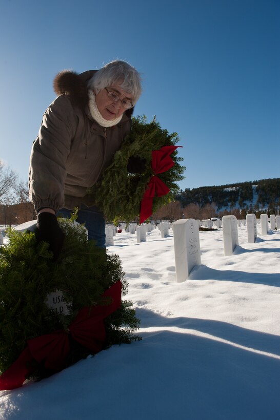 Vi Fenner lays a Christmas wreath on the grave of her sister-in-law as part of Wreaths Across America ceremony at the Black Hills National Cemetery near Sturgis, S.D., Dec. 10, 2011. This non-profit organization honors past and present servicemembers in ceremonies across the nation. (U.S. Air Force photo by Airman 1st Class Kate Thornton/Released)