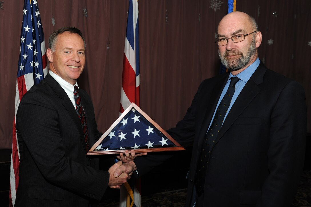 RAF CROUGHTON, United Kingdom - Tim Hershberger, 420th Air Base Squadron commander, presents Tim Small the honorary title of commander of the 420th ABS during the Honorary Commander Induction Ceremony Dec. 12. (U.S. Air Force photo by Tech. Sgt. John Barton)
