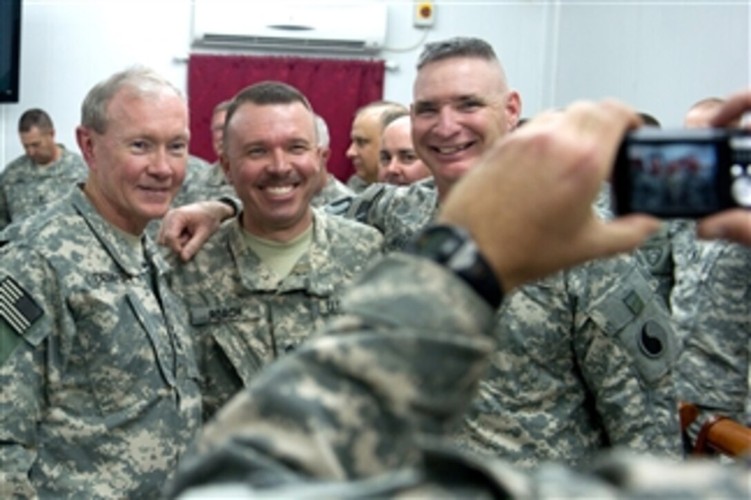 Chairman of the Joint Chiefs of Staff Gen. Martin E. Dempsey poses for a photo with members of the 1/1 Cavalry and 29th CAB at Camp Buehring, Kuwait, on Dec.14, 2011.  