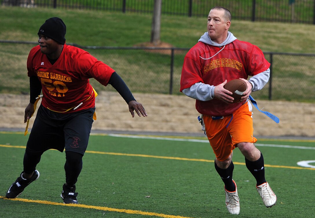 Staff Sgt. Kevin D. Pirtle, company gunnery sergeant, Company B, Marine Barracks Washington, follows his blocker for a first down during the first half of the Blood Stripe Bowl at the Barracks Dec. 15. The Barracks’ staff noncommissioned officers defeated the Barracks’ officers in the flag-football game. (Official Marine Corps Photo by Lance Cpl. Mondo Lescaud/Released)::r::::n::