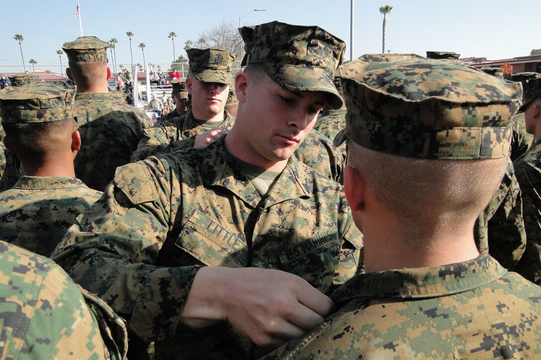 Sgt Little, an instructor with Field Medical Training Battalion West, Pins a student with his Medical Service Caduse during Graduation of FMST Class 2012010.