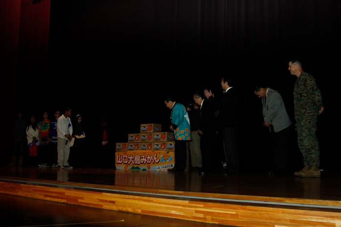 Matthew C. Perry Elementary School student counsel members bow in appreciation to Yoshihiko Fukudo, Iwakuni City mayor, Lt. Col. P.J. Kerr, Marine Corps Air Station Iwakuni executive officer, other distinguished guests and community leaders for the Mikans given during the 2nd annual Mikan Exchange at the Sakura Theater here Dec. 15. The Mikan fruit exchange gave the M.C. Perry children a taste, literally, of Japanese culture.