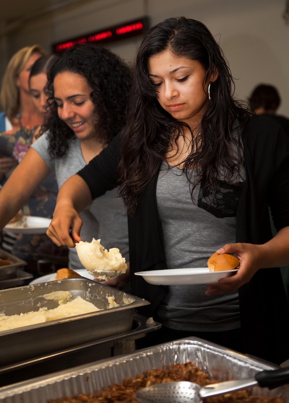 Lance Cpl. Monica Martinez, embark clerk at Headquarters and Service Battalion, U.S. Marine Corps Forces, Pacific, serves herself dinner at the MarForPac holiday party in the Pollock Theater here Dec. 16. The battalion hosts an annual holiday party for members of MarForPac to enjoy time together just before the holidays.