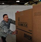 MINOT AIR FORCE BASE, N.D. – Master Sgt. Christopher Owen, 91st Operations Group first sergeant, loads a refrigerator onto a vehicle as part of a donation to the family of Master Sgt. John Neal, 705th Munitions Squadron missile maintenance NCO in charge, during Operation Homefront here Dec. 15. Operation Homefront was a charitable initiative headed by the Home Depot Foundation, in coordination with Minot AFB’s Operation Warm Heart and General Electric, which donated more than 130 appliances to Team Minot Airmen and their families affected by the historic Souris River flood. (U.S. Air Force photo/Senior Airman Desiree Esposito)