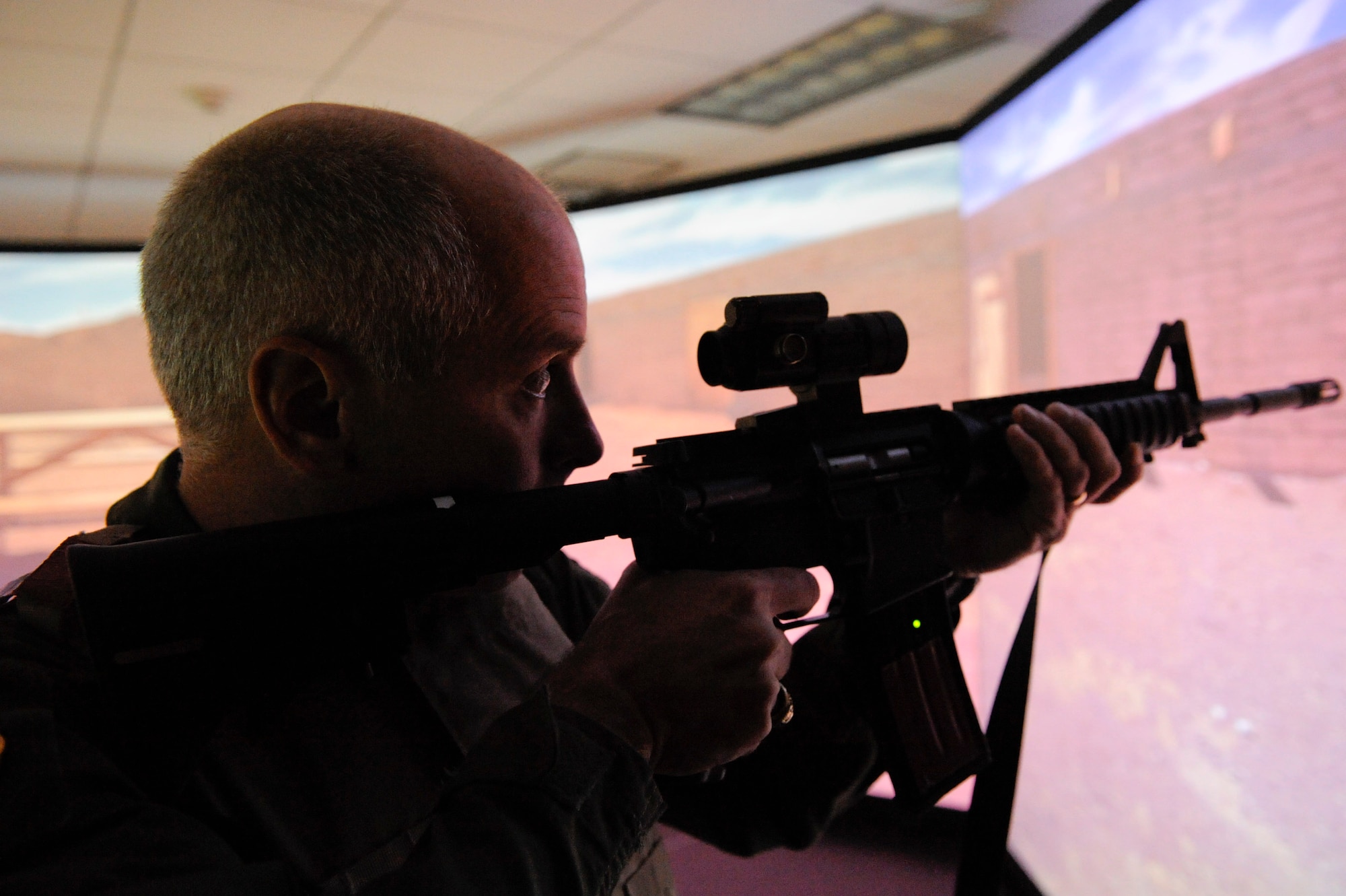 VANDENBERG AIR FORCE BASE, Calif. -- Col. Richard Boltz, the 30th Space Wing commander, fires at an aggressor while testing out the 30th Security Forces Squadron's new firearms training simulator at Combat Arms here Thursday, Dec. 15th, 2011. The new simulator provides a virtual training environment for Vandenberg members to practice real world combat tactics and train with firearms qualification scenarios. (U.S. Air Force/Staff Sgt. Levi Riendeau)