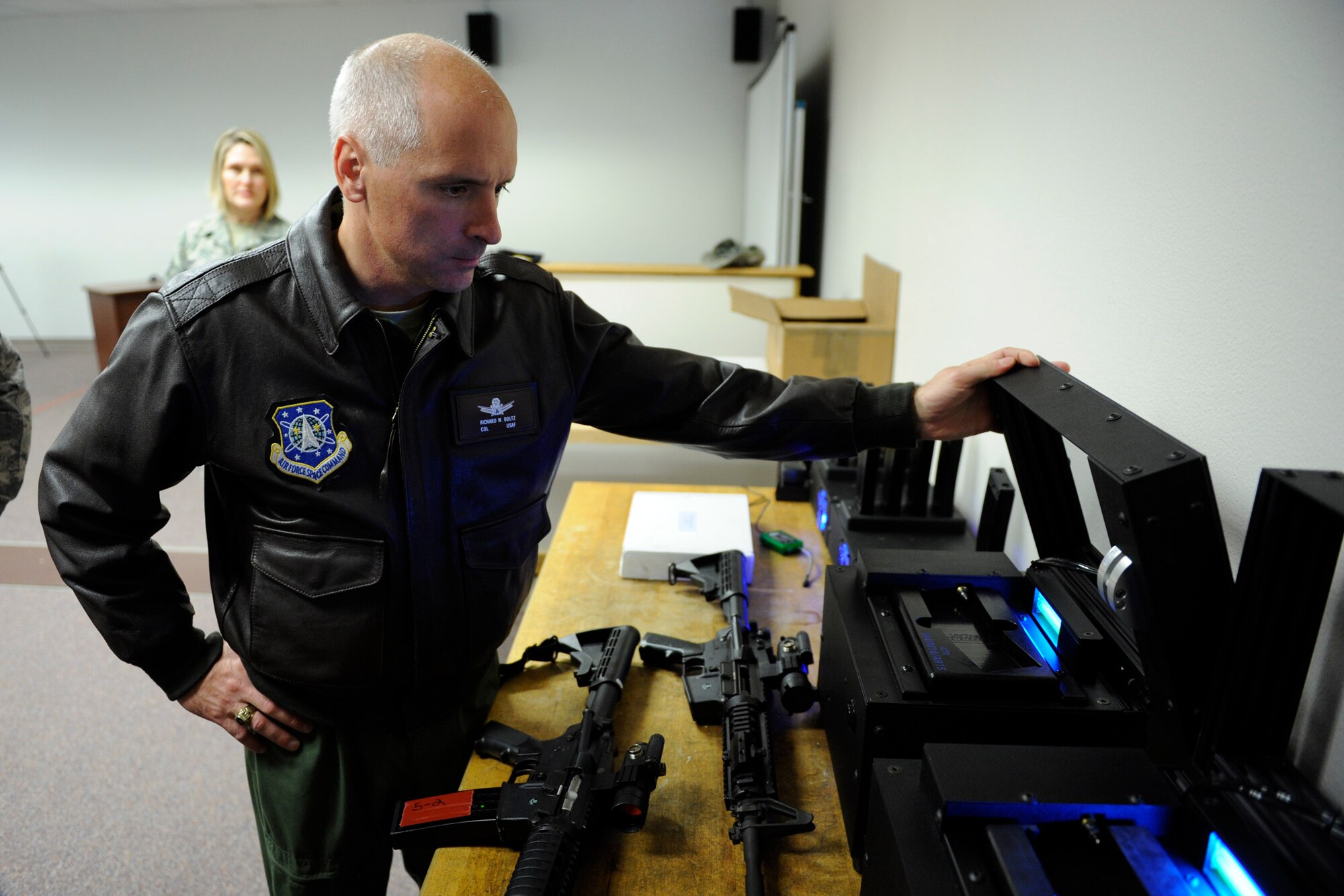 VANDENBERG AIR FORCE BASE, Calif. -- Col. Richard Boltz, the 30th Space Wing commander, surveys the equipment that charges training magazines with Carbon Dioxide, necessary for providing realistic recoil for firearms, for the 30th Security Forces Squadron's new firearms training simulator at Combat Arms here Thursday, Dec. 15th, 2011. The new simulator provides a virtual training environment for Vandenberg members to practice real world combat tactics and train with firearms qualification scenarios. (U.S. Air Force/Staff Sgt. Levi Riendeau)