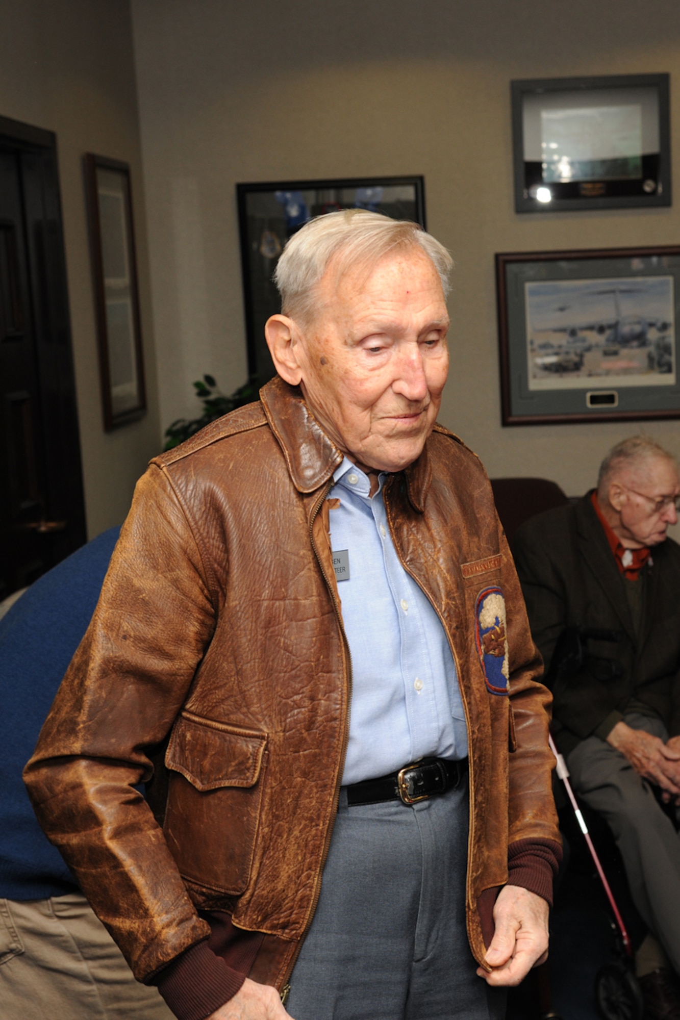 Retired Air Force Lt. Col. Bob Hansen dons his original bomber jacket he wore during World War II as a B-24 pilot. Hansen and his crew completed 30 bombing missions during the war, including providing close air support during the D-Day invasion and Battle of the Bulge in 1944. Hansen joined three other veterans of of the Battle of the Bulge at the U.S. Air Force Expeditionary Center Dec. 15 as part of a panel of the historic battle. (U.S. Air Force photo by Tech. Sgt. Zachary Wilson/Released.) 