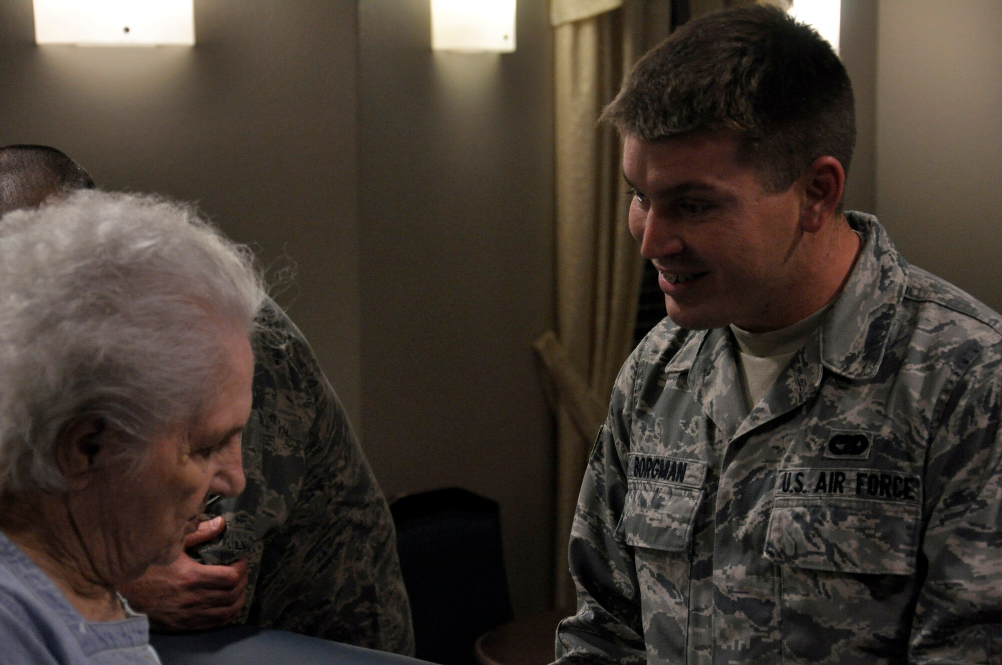 Senior Airman Adam Borgman, 1st Special Operations Logistics Readiness Squadron, visits with a resident of the Air Force Enlisted Village's Hawthorne House, at the house in Shalimar, Fla., Dec. 13, 2011. Borgman and other Hurlburt Field Airman's Voice members distributed the holiday cards to all 64 residents of the Hawthorne House. (U.S. Air Force photo/Staff Sgt. William Banton)(Released)