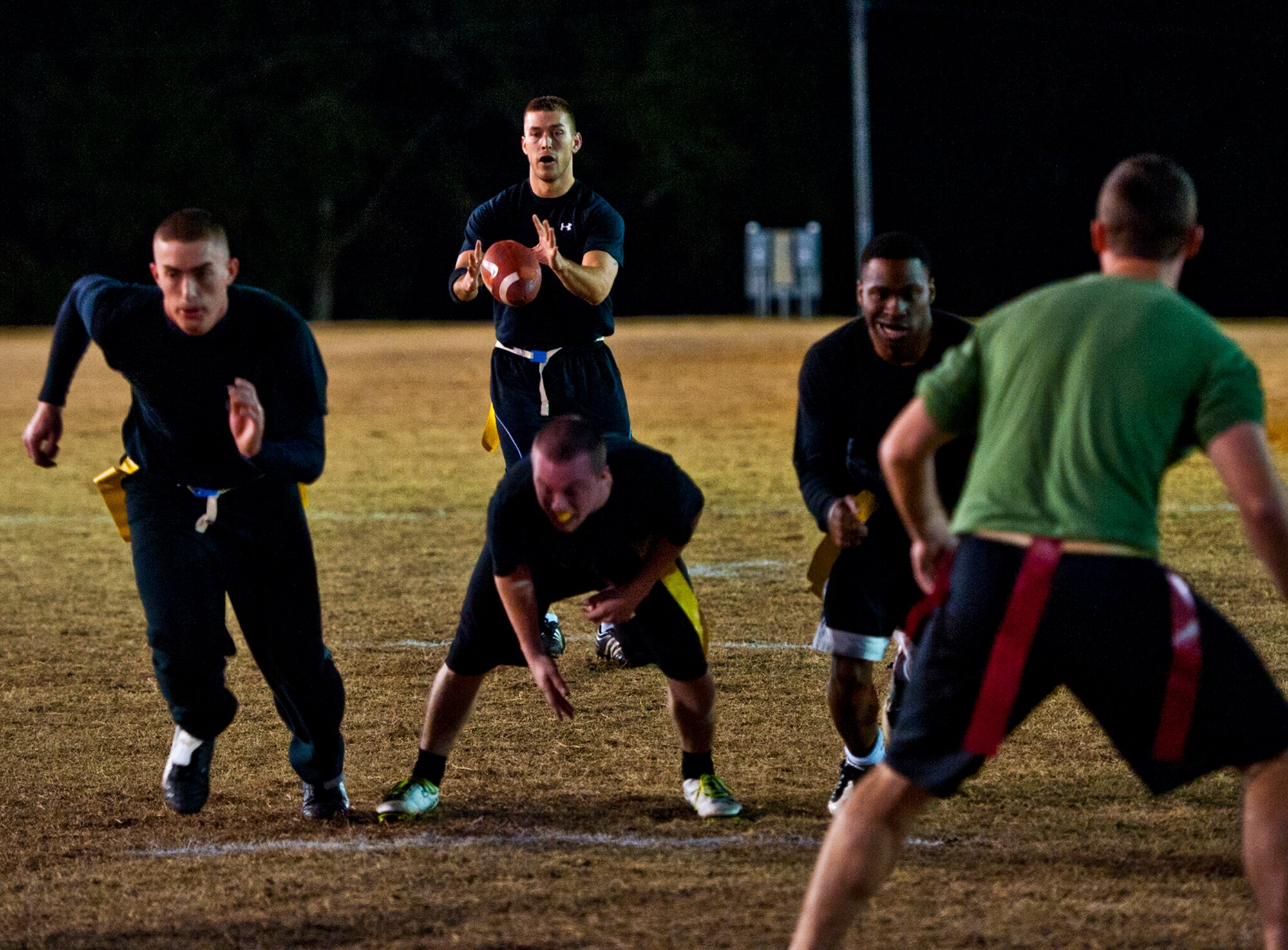 James Baker, the 96th Security Forces Squadron quarterback, takes the snap at the goal line during the base intramural flag football championship game against the Air Armament Center Dec. 15 at Eglin Air Force Base, Fla.  SFS beat the Air Armament Center team 19-14 to claim the title.  It had been three years since they’d been the champs.  (U.S. Air Force photo/Samuel King Jr.)
