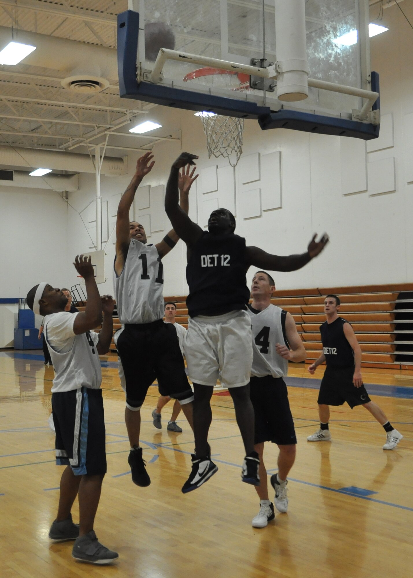 Airmen from the 627th Security Forces Squadron struggle to take control of the ball while the 373rd Training Squadron Det. 12 makes a shot during the first game of a four-day intramural basketball tournament Dec. 8, 2011, at Joint Base Lewis-McChord, Wash. The 373rd TRS defeated the 627th SFS 58-35. (U.S. Air Force photo/Airman 1st Class Leah Young) 