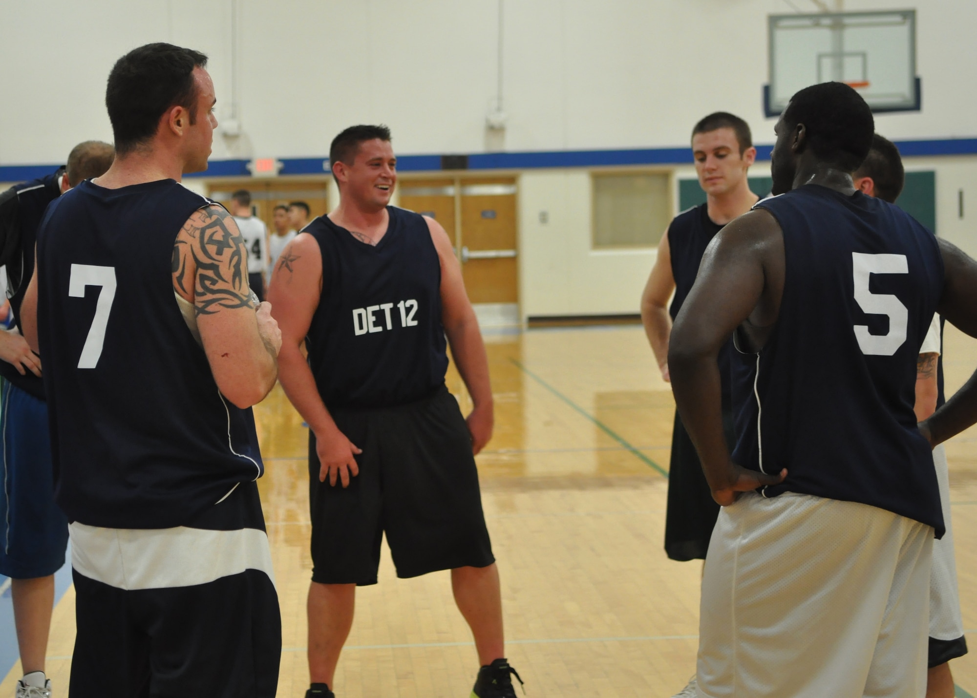Airmen from the 373rd Training Squadron Det. 12 share a laugh at halftime during the first game of a four-day intramural basketball tournament Dec. 8, 2011, at Joint Base Lewis-McChord, Wash. The 373rd TRS defeated the 627th Security Forces Squadron 58-35 (U.S. Air Force photo/Airman 1st Class Leah Young) 