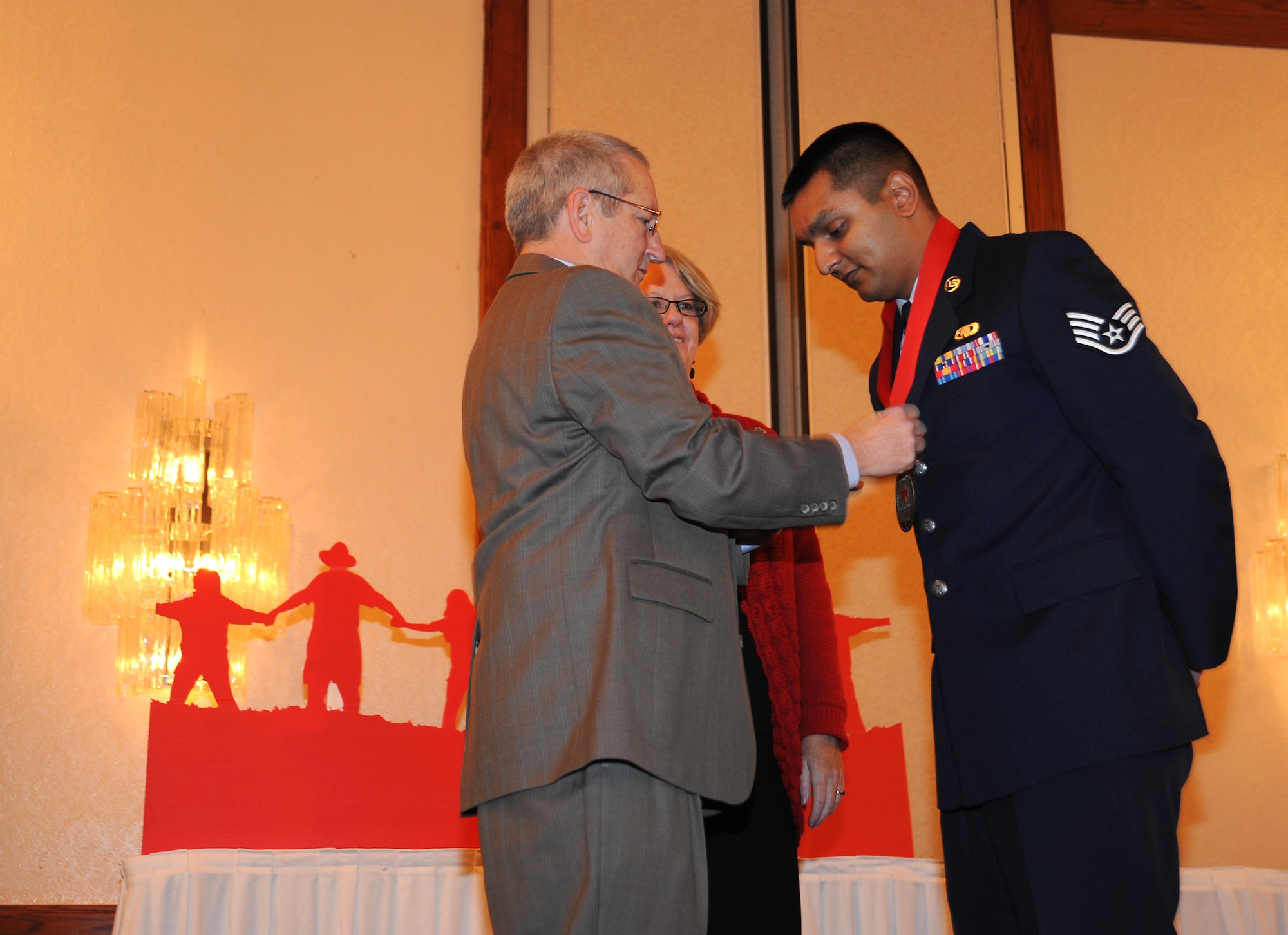 Staff Sgt. David Perry, 22nd Air Refueling Wing NCO in charge of religious program support, receives the Military Hero Award from Jack Hall, a Capital Federal representative, during the Wichita Heroes Breakfast Dec. 14, 2011, Wichita, Kan. The award is presented to a member of the armed forces, or the Reserve Officer Training Corps, who acts above and beyond the call of duty.  (U.S. Air Force photo/Airman 1st Class Jose L. Leon)