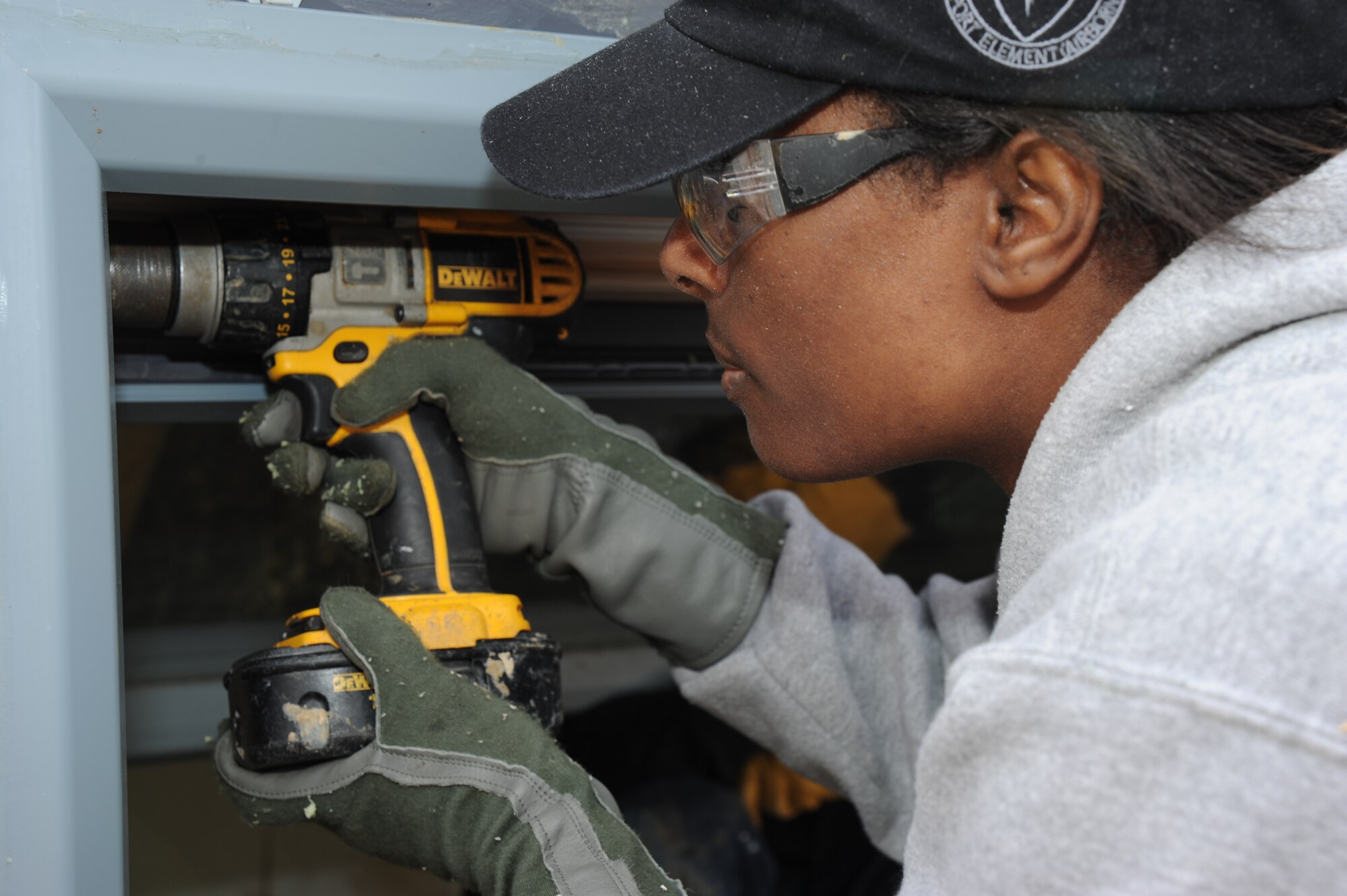 1st Lt. Temesha Madison, 844th Communication Group executive officer, Joint Base Andrews, Md., removes the hinges of a window to be used in a new home Dec. 15 in Washington D.C. "We are building the solar passive home," said Madison. "We wanted to get involved with the environmentally friendly build, and provide a home in our community." (U.S. Air Force photo by Staff Sgt. Christopher Ruano)
