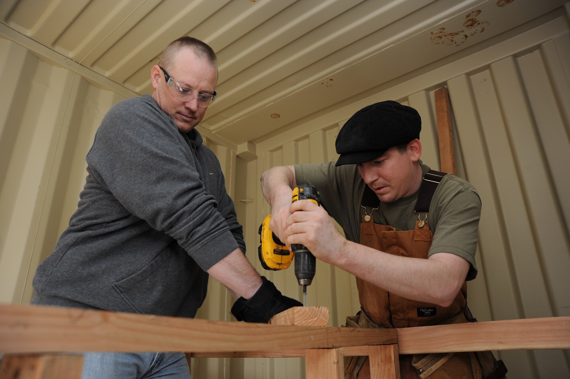 Master Sgt. Erik Doyle, 844th Communication Squadron First Sgt., Joint Base Andrews, Md., holds a piece of wood steady while Staff Sgt. Clifton Goodson, 744th Communication Squadron noncommissioned officer in charge of radio frequency transmissions, Joint Base Anacostia-Bolling, D.C., secures the wood with a screw Dec. 15 in Washington, D.C. Twenty two members from the 844th Communication Group are contributing more than 140 man-hours towards the build Dec. 15 and 16. (U.S. Air Force photo by Staff Sgt. Christopher Ruano)