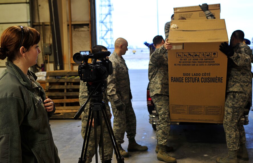 MINOT AIR FORCE BASE, N.D. – Airman 1st Class Geni Oslund, 5th Bomb Wing broadcaster, documents First Sergeants loading donated appliances during Operation Homefront here Dec. 15. Operation Homefront and the Home Depot Foundation in coordination with Minot AFB’s Operation Warmheart and General Electric distributed 135 appliances to Team Minot Airmen and their families affected by the historic Souris River flood. (U.S. Air Force photo/Senior Airman Desiree Esposito)
