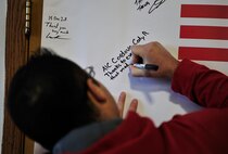 MINOT AIR FORCE BASE, N.D. – Airman 1st Class Cody Cordova, 791st Missile Security Forces Squadron member, signs an Operation Homefront thank you banner after receiving appliances donated to his family, here Dec. 15. Operation Homefront and the Home Depot Foundation in coordination with Minot AFB’s Operation Warmheart and General Electric distributed 135 appliances to Team Minot Airmen and their families affected by the historic Souris River flood. (U.S. Air Force Photo/Senior Airman Desiree Esposito)