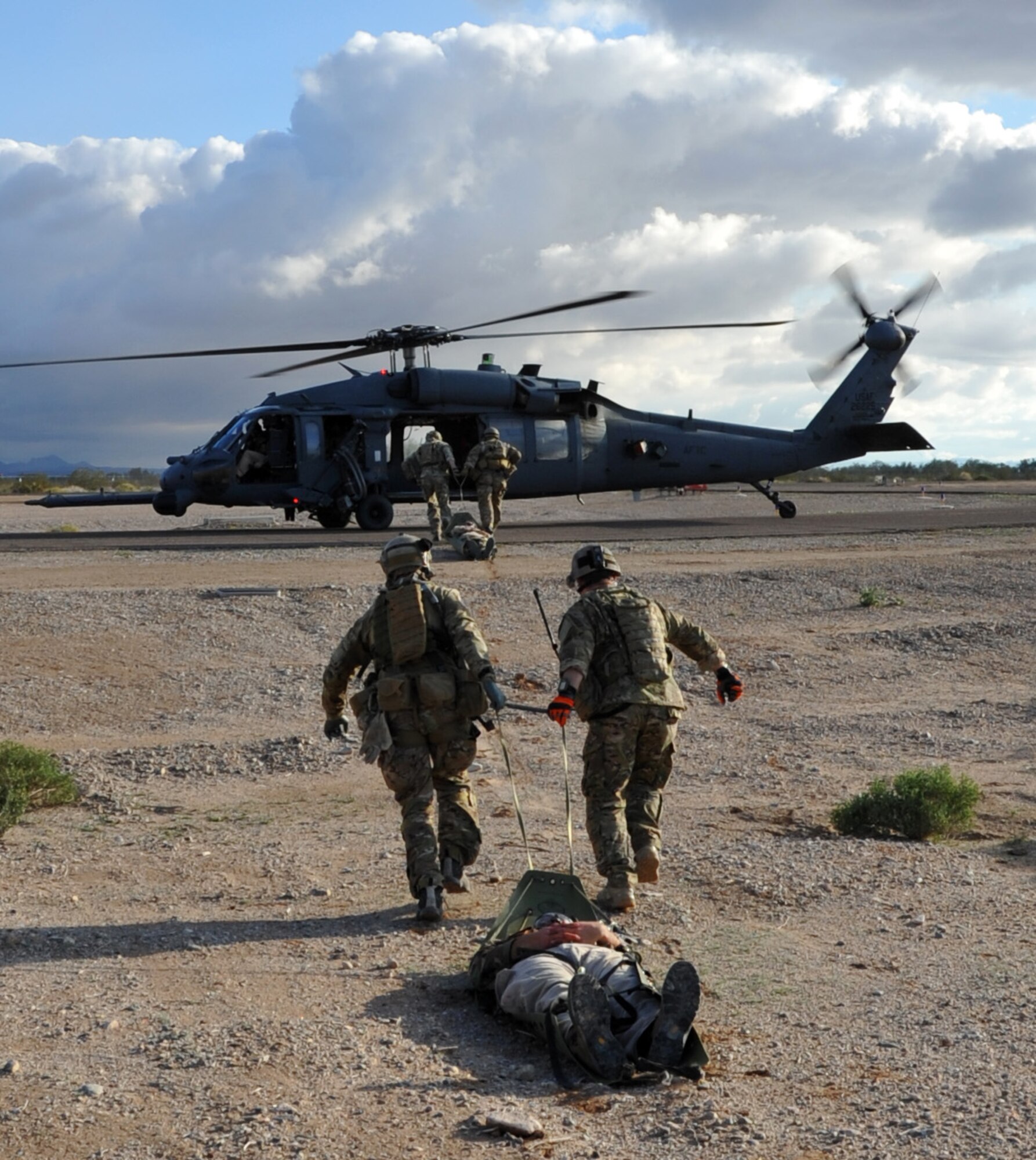 Pararescuemen drag patients on a sled to a HH-60G Pave Hawk helicopter during a mass causality drill as part of Operation Shocker, a training exercise designed to hone 943rd Rescue Group Airmen’s combat-search-and-rescue skills. (U.S. Air Force Photo/ Master Sgt. Luke Johnson) 