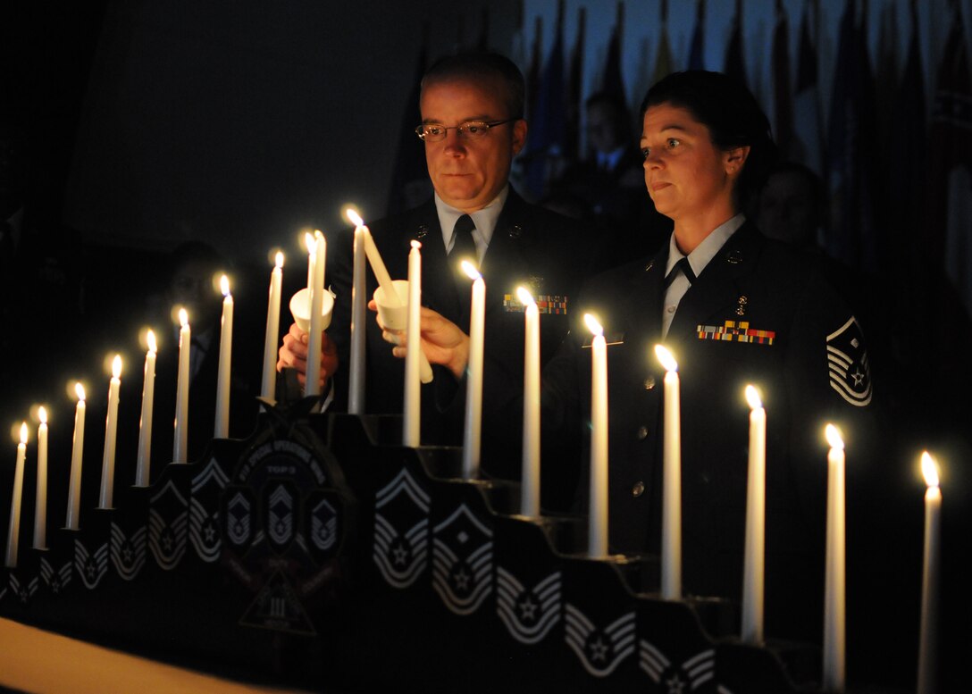 Master Sgts. Matthew Marrier and Jessica McBride light candles during the 919th Special Operations Wing’s recent combined Senior NCO and NCO induction ceremony at Duke Field, Fla.   The formal ceremony honors wing reservists entering the top two tiers of enlisted leadership and signifies their acceptance of increased responsibilities as new Senior NCOs and NCOs. (U.S. Air Force photo/Tech. Sgt. Cheryl Foster)