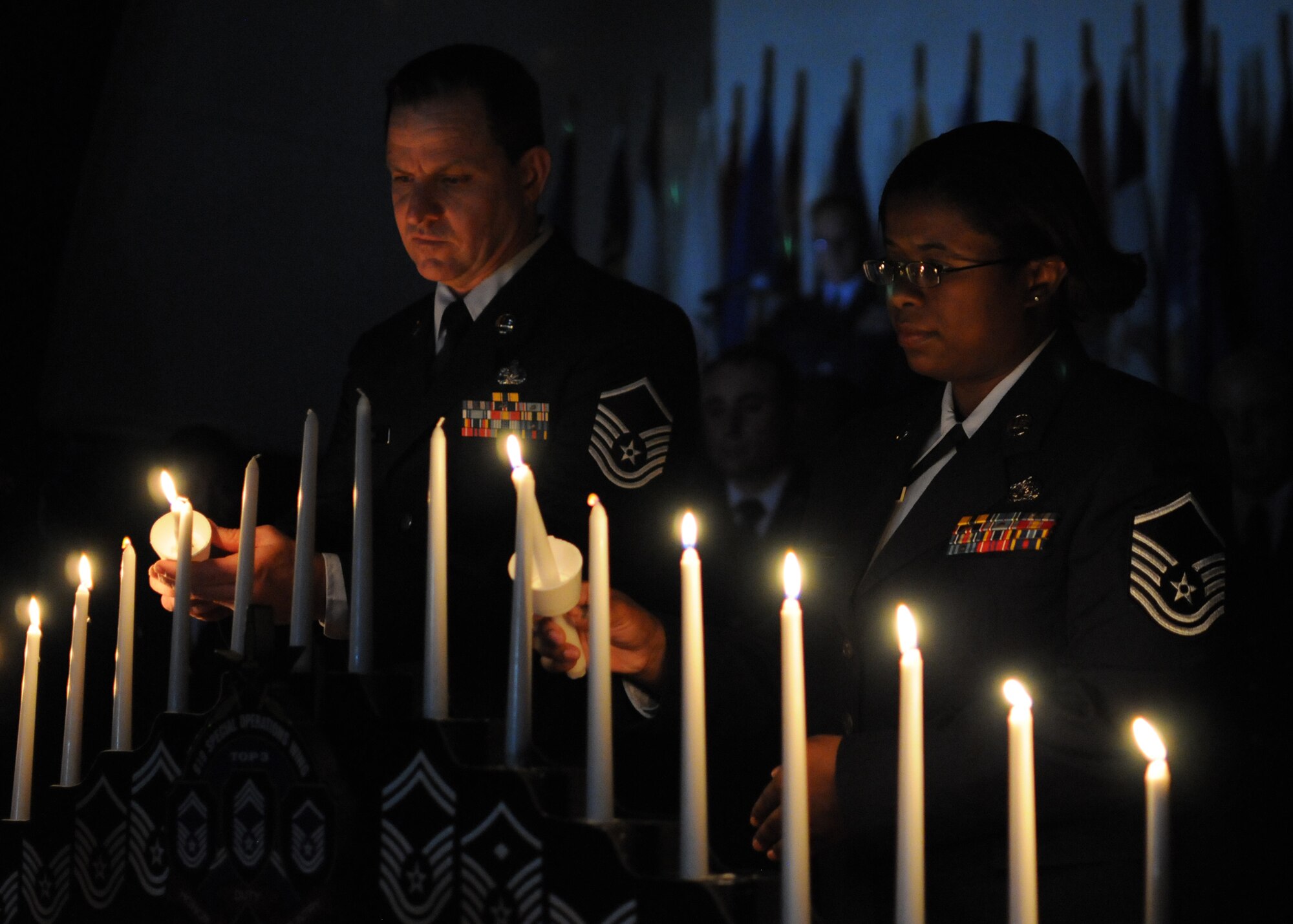 Master Sgts. Kenneth Kent and Tiffany Prophet light candles during the 919th Special Operations Wing’s recent combined Senior NCO and NCO induction ceremony at Duke Field, Fla.   The formal ceremony honors wing reservists newly promoted to the top two tiers of enlisted leadership and signifies their acceptance of increased responsibilities as new Senior NCOs and NCOs. (U.S. Air Force photo/Tech. Sgt. Cheryl Foster)