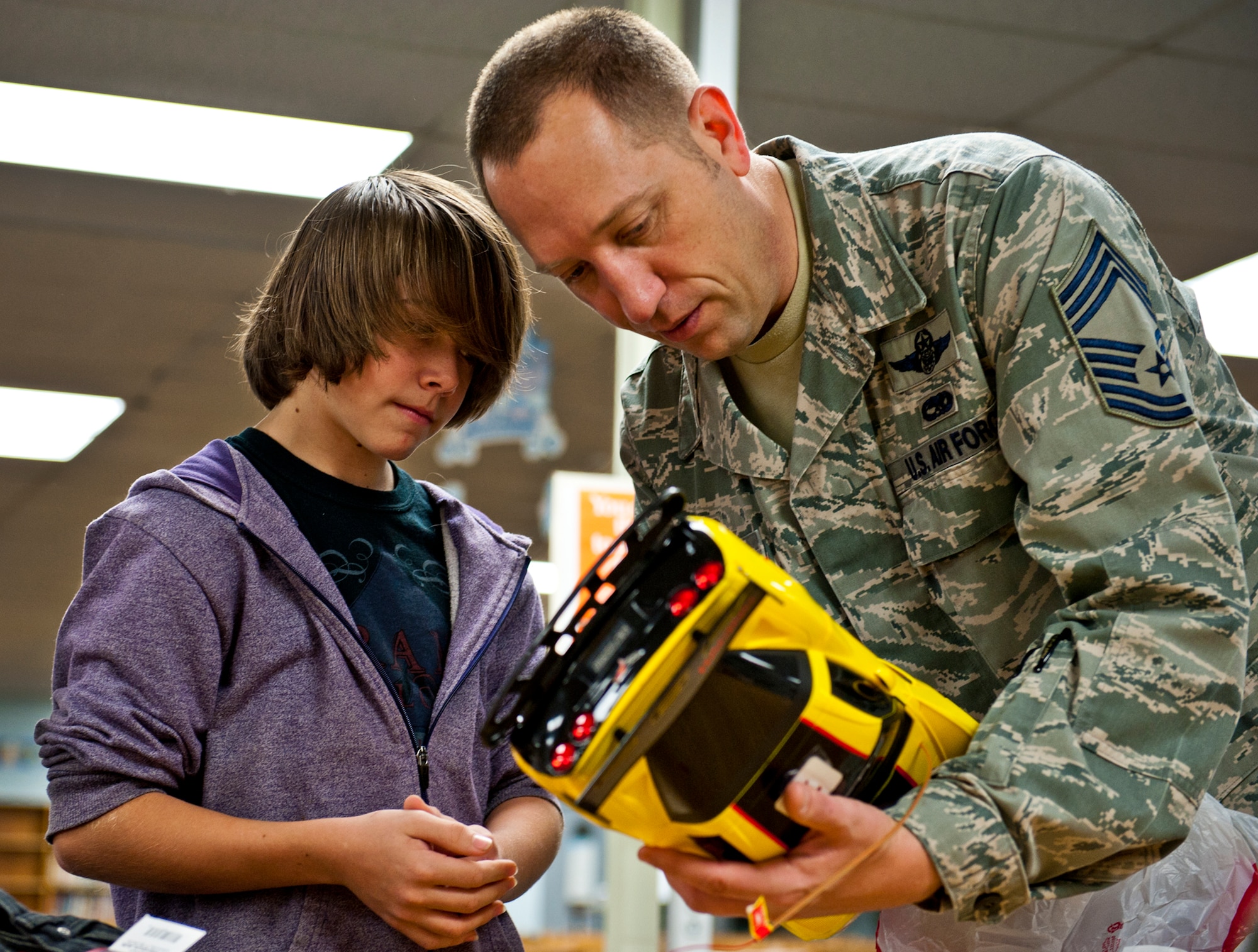 Chief Master Sgt. Robert Boyer, from the 46th Operations Group, checks out Joltan Williams’ new remote control corvette Dec. 15 at Bruner Middle School.  Squadrons from the 46th Operations Group adopted 14 needy families from the school and provided them with food and gifts for the holidays.  (U.S. Air Force photo/Samuel King Jr.)