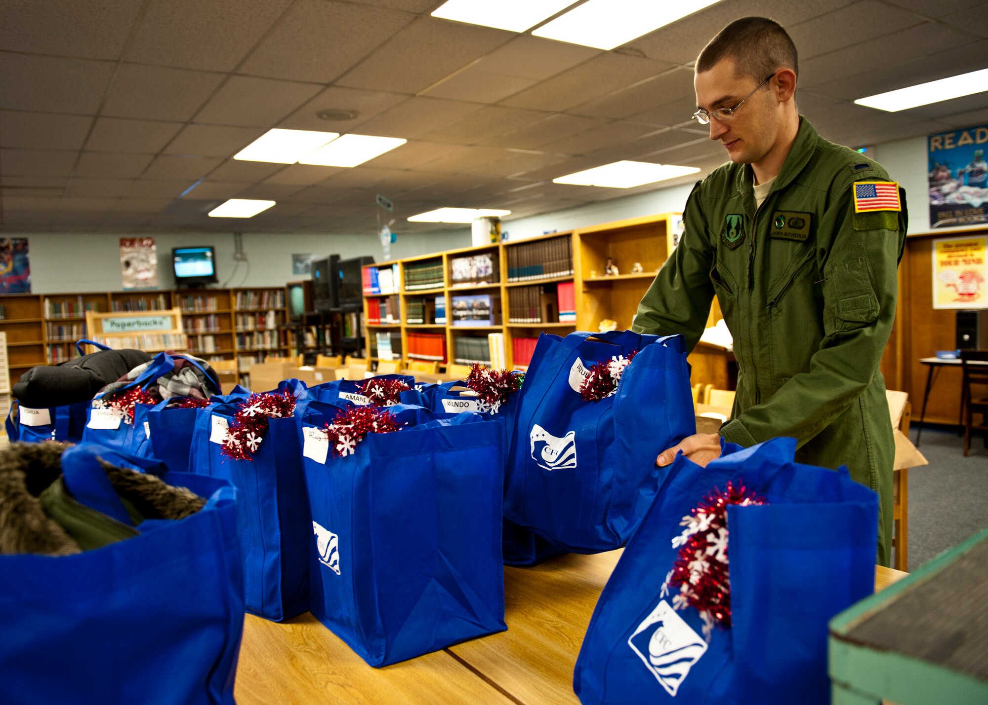 1st Lt. Jason Sutherlin, of the 413th Flight Test Squadron, places gift bags for a family in need Dec. 15 at Bruner Middle School.  Squadrons from the 46th Operations Group adopted 14 needy families from the school and provided them with food and gifts for the holidays.  (U.S. Air Force photo/Samuel King Jr.)