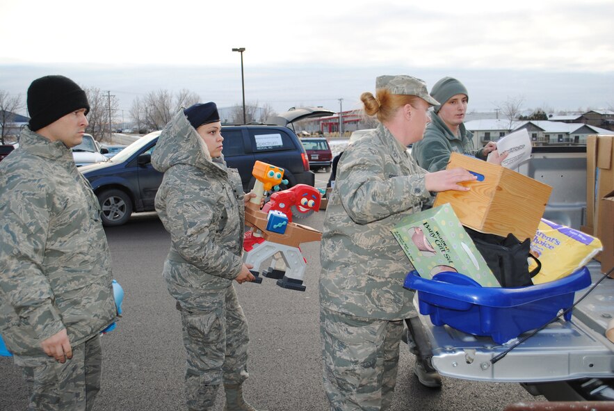 From left to right, Staff Sgt. Mark Crespo, 341st Missile Security Forces Squadron member; Airman 1st Class Michelle Bond, 341st MSFS member; Special Agent Suzanne Krasnow; and Senior Airman Timothy Mumme, 341st MSFS member, unload a truck of donations for the Child Evaluation Center Dec. 12. The center takes in children from battered or broken homes and provides them with whatever they need to help them feel more secure. Donations are always welcome and anyone interested should contact Chris Levine at 799-6306. (U.S. Air Force photo/Airman Cortney Paxton)