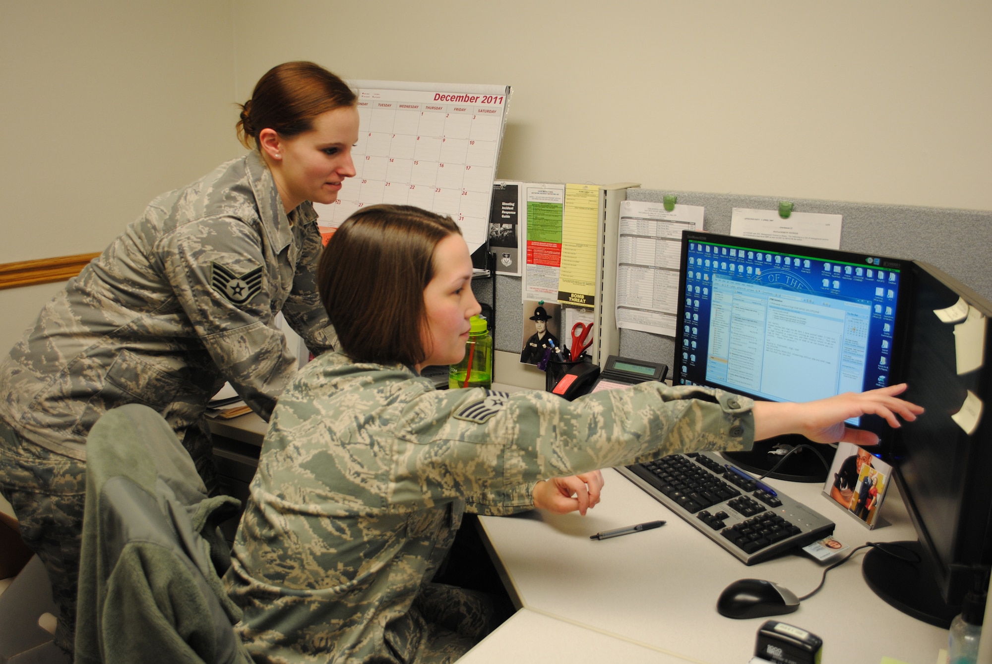Staff Sgt. Jessica Piotrowski, 341st Comptroller Squadron financial services technician, looks over the shoulder of Staff Sgt. Melissa Clouatre, 341st CPTS financial services representative, as she points out a discrepancy with some computer work. (U.S. Air Force photo/Airman Cortney Paxton)