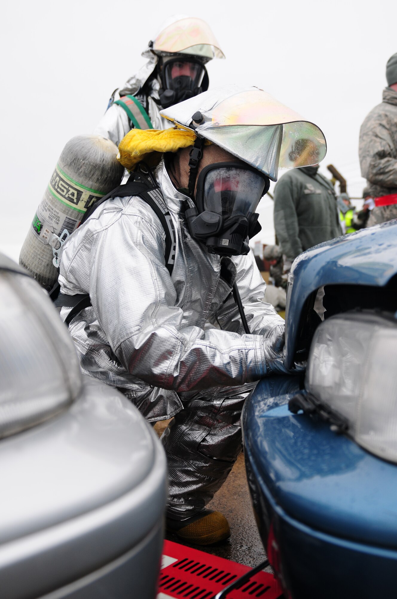 ROYAL AIR FORCE LAKENHEATH, England - Staff Sgt. Christopher Brown (front) and Airman 1st Class Dustin Dawson, 48th Civil Engineer Squadron firefighters, prepares to inspect a vehicle after a simulated collision during the NATO Tactical Evaluation, Dec. 15, 2011. The exercise measured the 48th Fighter Wing's ability to respond to a contingency situation. (U.S. Air Force photo by Senior Airman Lausanne Morgan)