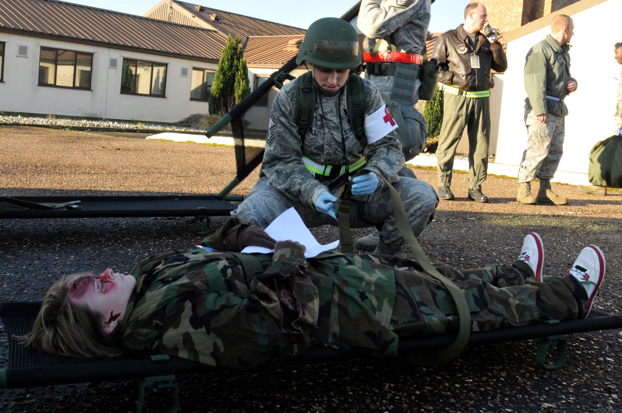 ROYAL AIR FORCE LAKENHEATH, England - Senior Master Sgt. Heather Krell, 48th Inpatient Squadron independent duty medical technician, secures Staff Sgt. Briana Tinsley, 48th Security Forces Squadron commander's support staff NCO in charge, to a litter during the NATO Tactical Evaluation, Dec. 15, 2011. The exercise measured the 48th Fighter Wing's ability to respond to a contingency situation. (U.S. Air Force photo by Staff Sgt. David Dobrydney)
