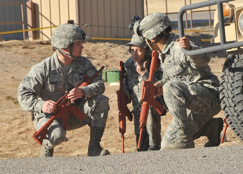 Senior Airman Zackary Mengel, left, and Airman First Class Jorge Lopez, right, both with the 377th Weapons System Security Squadron, prepare to “storm a building” Dec. 10 with Wyatt Hoover, who had a wish to visit Kirtland Air Force Base. U.S. Air Force Photo by Todd Berenger.