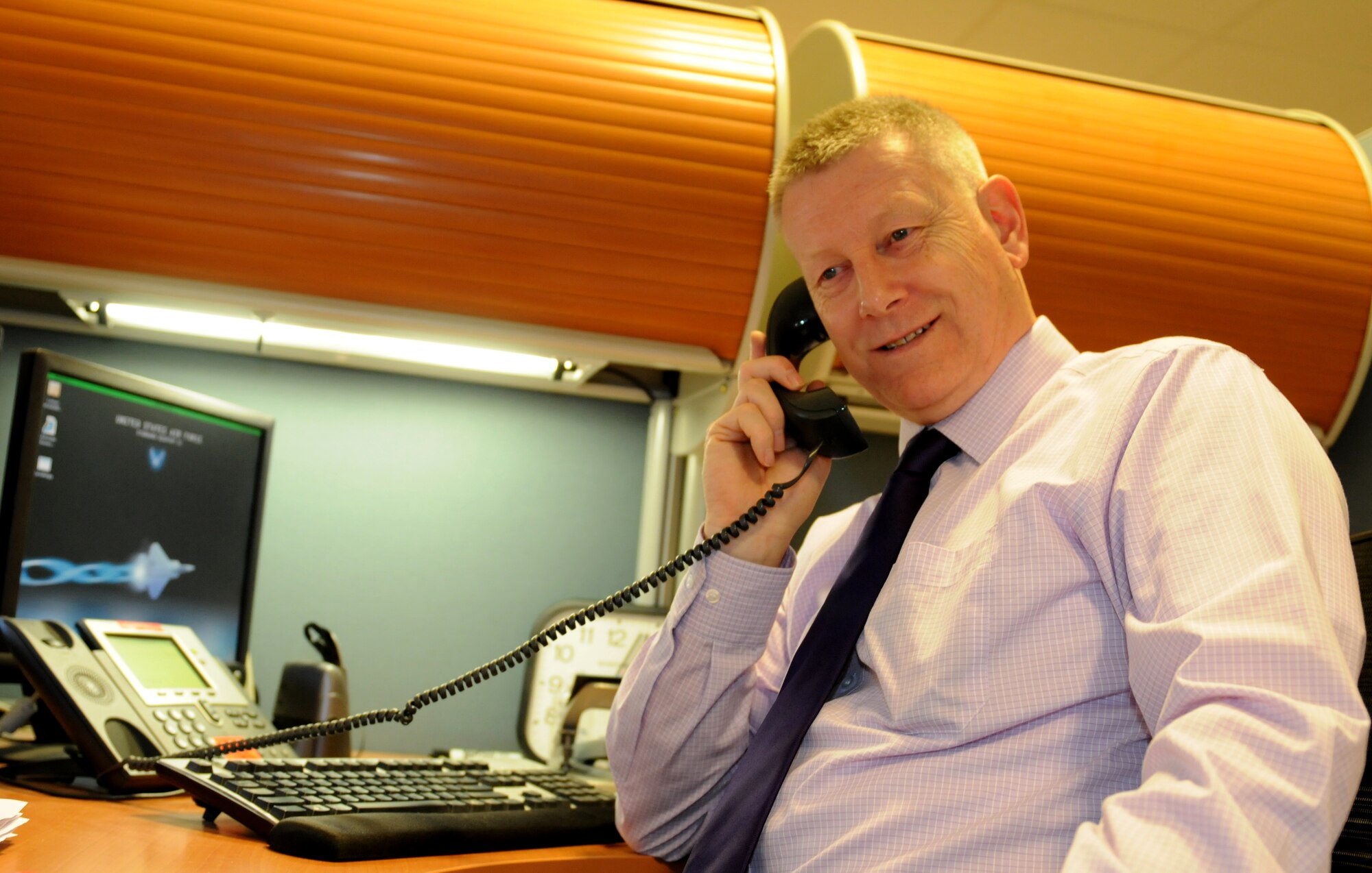ROYAL AIR FORCE LAKENHEATH, England -- Alan Rose, 48th Contracting Squadron contracting officer, speaks on the phone on Dec. 15, 2011. Rose was nominated for a Liberty Spotlight because he displays the core value of 'Service Before Self'. (U.S. Air Force photo by Airman 1st Class Cory Payne)