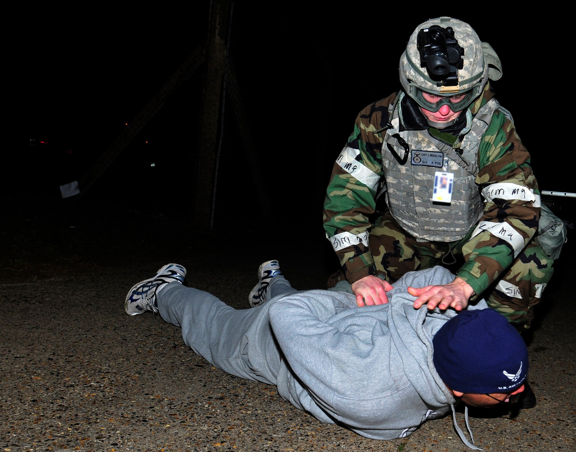 ROYAL AIR FORCE LAKENHEATH, England – Senior Airman Cody Brazelton, 48th Security Forces Squadron confinement guard, restrains Tech. Sgt. Mark Burleson, 48th Communications Squadron postmaster, during the NATO Tactical Evaluation, Dec. 14, 2011. Burleson acted as a protester that tried to break through the entry control point. The exercise measured the 48th Fighter Wing’s ability to respond to a contingency situation. (U.S. Air Force photo by Senior Airman Tiffany M. Deuel)
