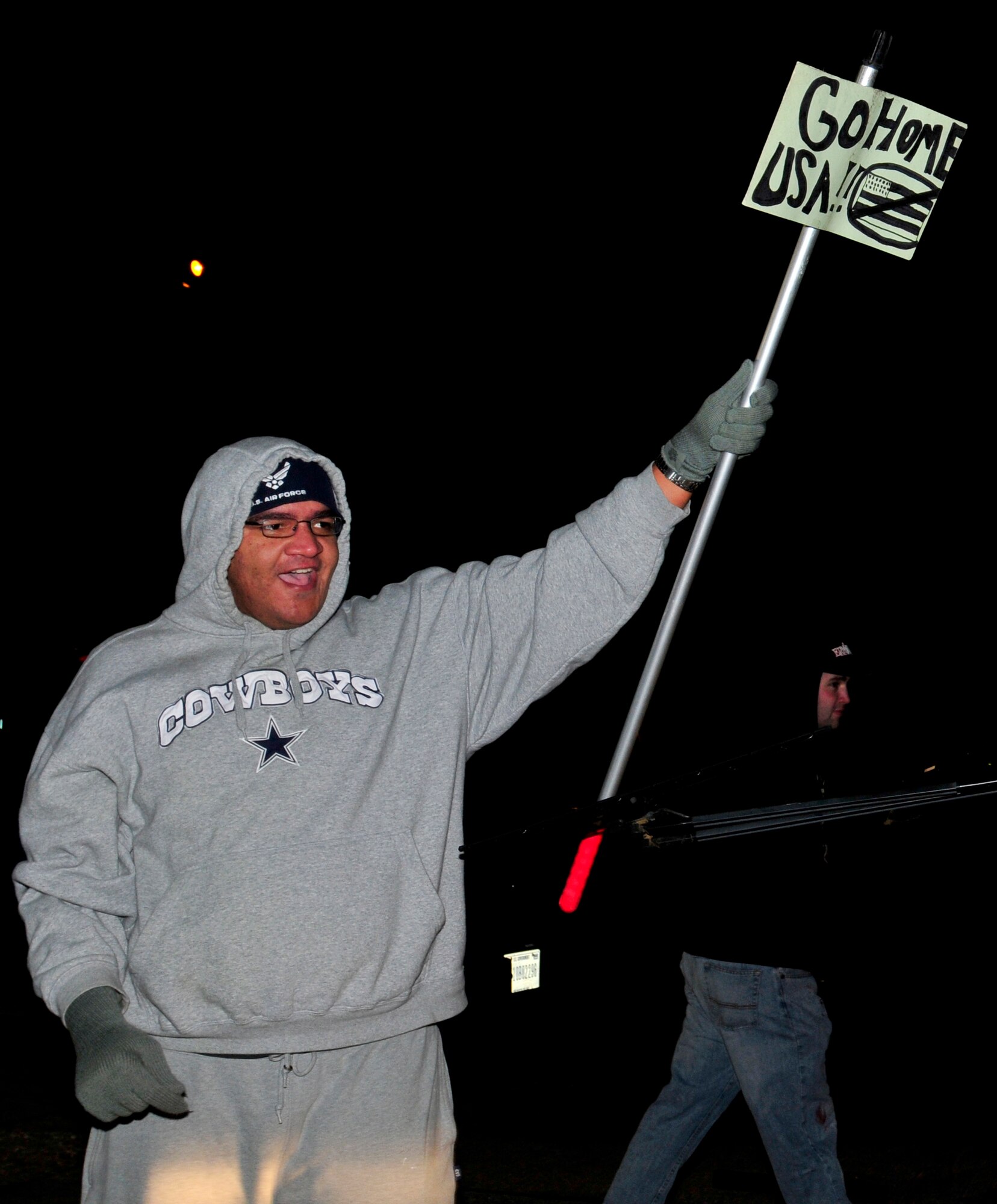 ROYAL AIR FORCE LAKENHEATH, England – Protesters rally outside the entry control point on the flightline during the NATO Tactical Evaluation, Dec. 14, 2011. The exercise measured the 48th Fighter Wing’s ability to respond to a contingency situation. (U.S. Air Force photo by Senior Airman Tiffany M. Deuel)