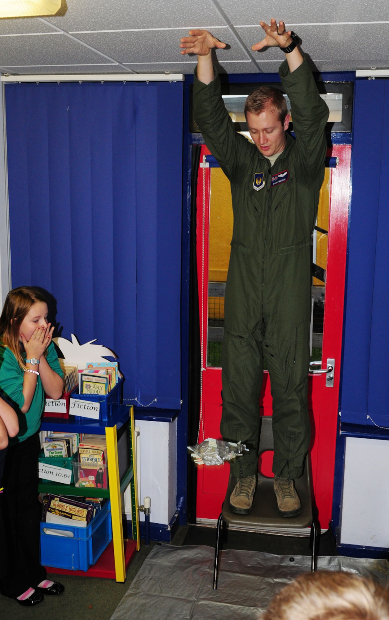 MILDENHALL, England – 1st Lt. Mark Watson, 351st Air Refueling Squadron pilot, drops a “lunar pod” from a height of about 8 feet Dec. 6, 2011, at Great Heath Primary School, Mildenhall.  The children who created them watched and cheered as their lunar pod made its landing, to see if their “astronaut” eggs inside the pods made it out safely or not. All the eggs remained intact after the experiment. (U.S. Air Force photo/Karen Abeyasekere)