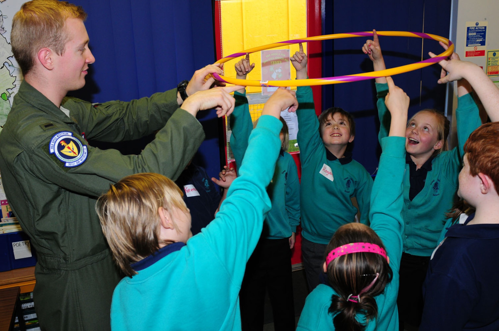 MILDENHALL, England – 1st Lt. Mark Watson, 351st Air Refueling Squadron pilot, helps children of Willow class, Great Heath Primary School, Mildenhall, during a team-building exercise Dec. 6, 2011. Watson visited the school during their Space Week event and spent the afternoon with them talking about topics including the history of aviation, space shuttle launch and landings, and the importance of health and fitness for pilots. (U.S. Air Force photo/Karen Abeyasekere)