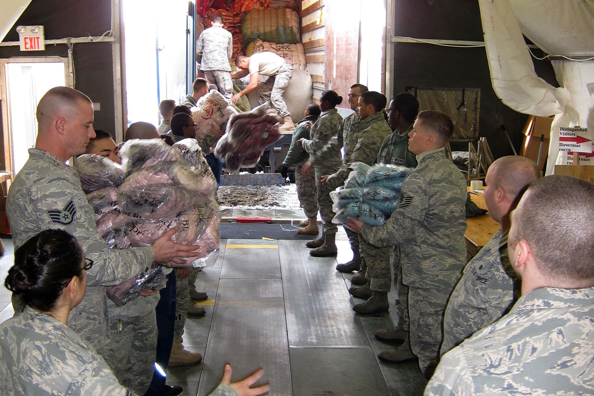 A group of Airmen and Soldiers unload a delivery truck full of blankets and jackets at the Transit Center at Manas, Kyrgyzstan, Dec. 14, 2011, that will be given to Kyrgyz citizens as part of Operation Warm and Dry. The group sorted more than 3,600 jackets by size and gender and packaged 500 blankets. (U.S. Air Force photo/Senior Master Sgt. Mark Redden)