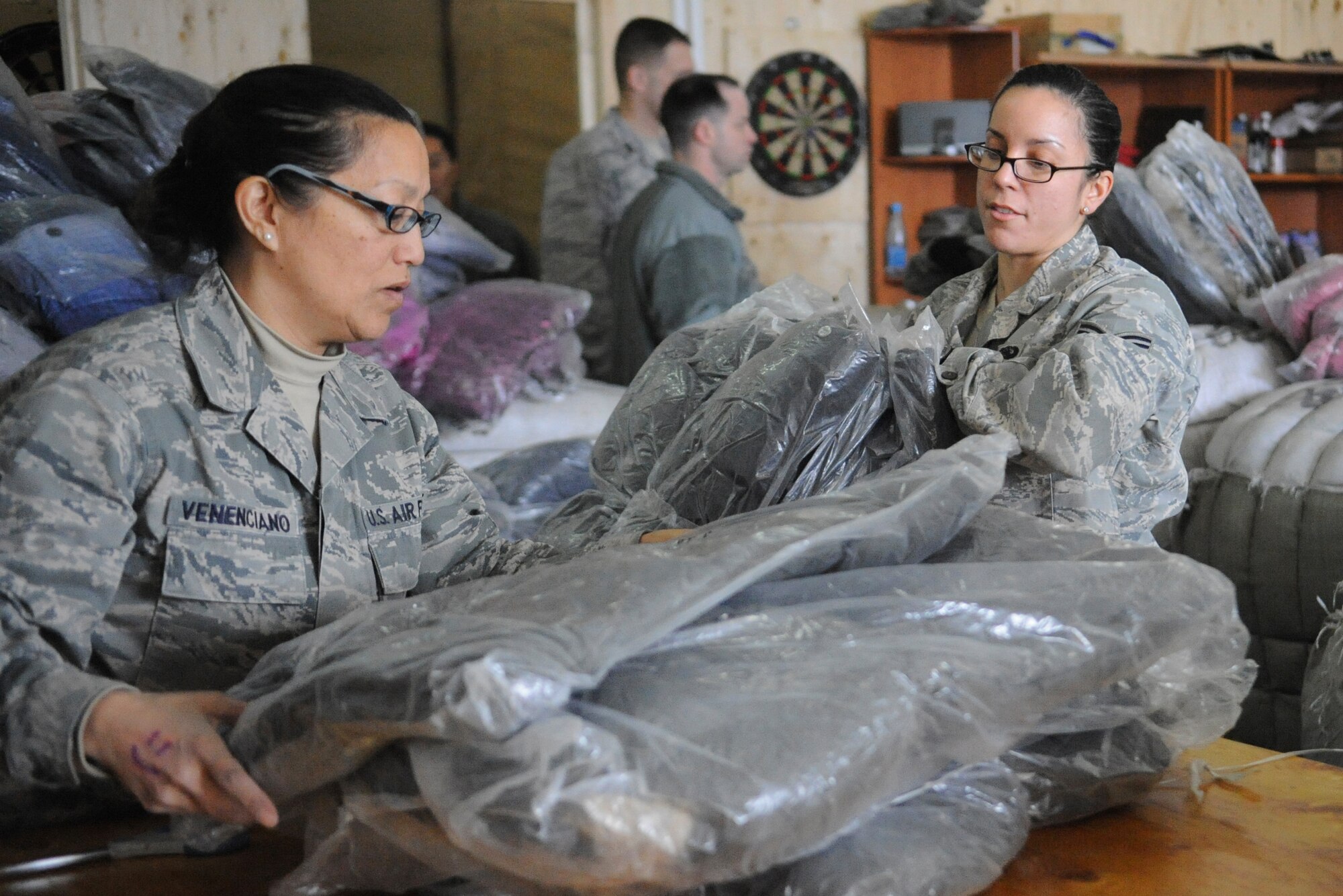 Master Sgt. Jane Venenciano and Senior Airman Natasha Flores sort jackets by size at the Transit Center at Manas, Kyrgyzstan, Dec. 14, 2011. The jackets will be donated to Kyrgyz citizens through Operation Warm and Dry. Venenciano is deployed to the 376th Expeditionary Logistics Readiness Squadron as the NCO in charge of the passenger terminal from Travis Air Force Base, Calif. Flores is deployed to the 376th Expeditionary Communications Squadron from Joint Base Pearl Harbor-Hickam, Hawaii. (U.S. Air Force photo/Tech. Sgt. Tammie Moore)
