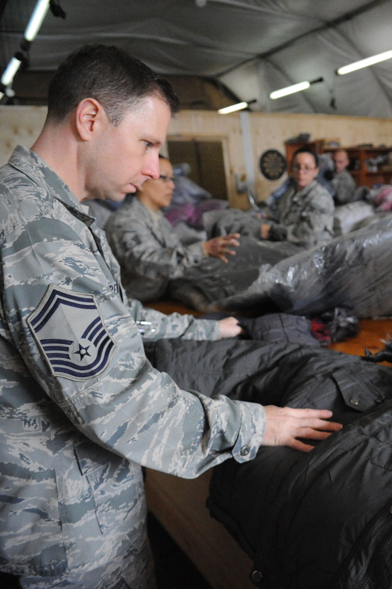 Senior Master Sgt. Mark Redden checks the size of a jacket at the Transit Center at Manas, Kyrgyzstan, Dec. 14, 2011, that will be given to a Kyrgyz child as part of Operation Warm and Dry. Operation Warm and Dry is a Transit Center humanitarian assistance program which provides blankets and coats to "at-risk" populations of Kyrgyzstan. Redden is deployed as the 376th Air Expeditionary Wing Theater Security Corporation superintendent from Scott Air Force Base, Ill. (U.S. Air Force photo/Tech. Sgt. Tammie Moore)