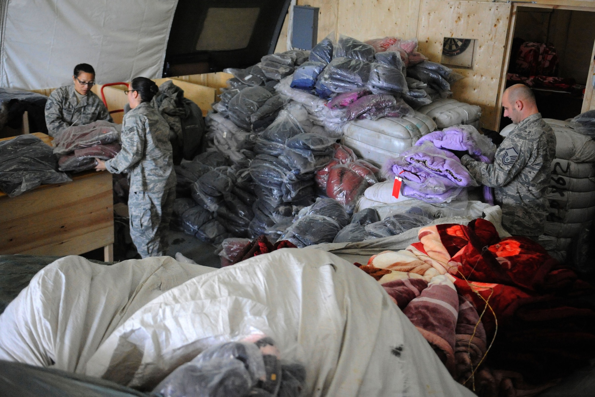 Airmen sort jackets and blankets to give to Kyrgyz citizens as part of Operation Warm and Dry at the Transit Center at Manas, Kyrgyzstan, Dec. 14, 2011. A group of Airmen and Soldiers processed more than 3,600 jackets and 500 blankets worth $102,000 that will be given to Kyrgyz citizens through Operation Warm and Dry. (U.S. Air Force photo/Tech. Sgt. Tammie Moore)