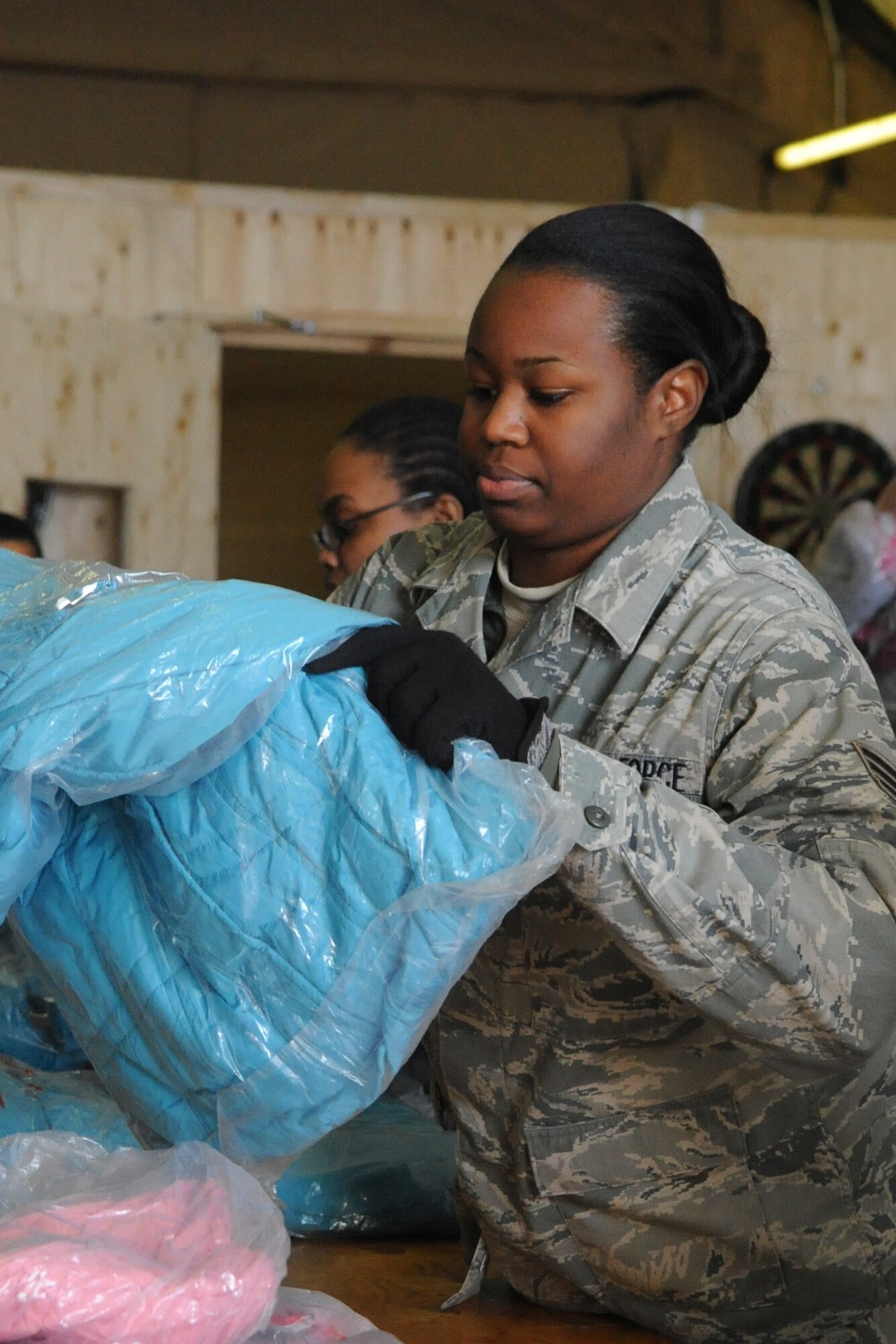 Senior Airman Reana Charles sorts jackets by size at the Transit Center at Manas, Kyrgyzstan, Dec. 14, 2011. The jackets will be donated to Kyrgyz citizens through Operation Warm and Dry, an annual Transit Center humanitarian assistance program which provides blankets and coats to "at-risk" populations of Kyrgyzstan. Charles is deployed to the 376th Expeditionary Logistics Readiness Squadron as a storage and issue technician from Cannon Air Force Base, N.M. (U.S. Air Force photo/Tech. Sgt. Tammie Moore)