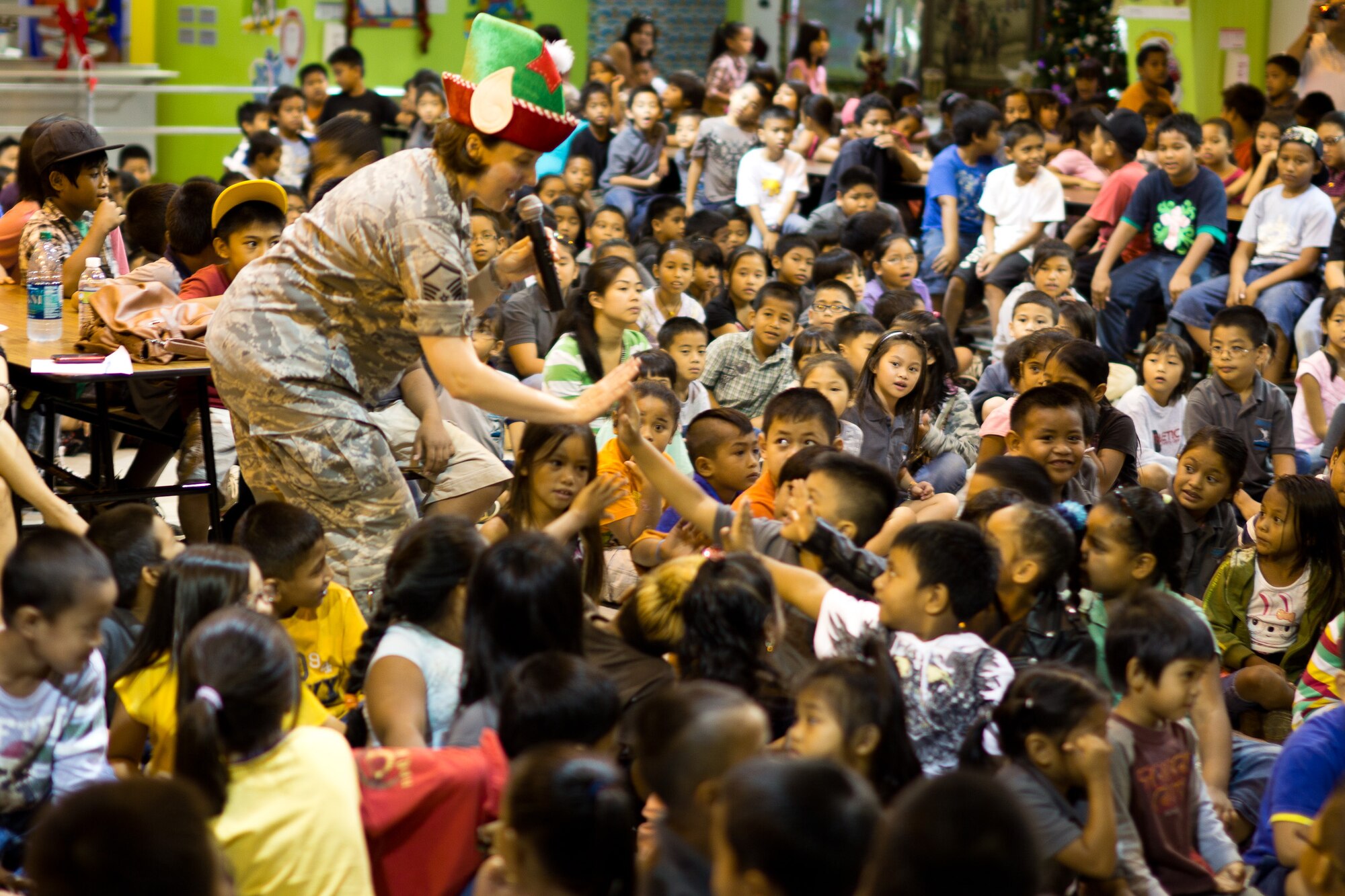 YIGO VILLAGE, Guam -- Master Sgt. Paula Goetz, Band of the Pacific-Asia vocalist, "high-fives" students at the Machanano Elementary School, Yigo Village, Guam, Dec. 13, 2011. Goetz regularly engaged the audience during the show to make them feel like they were part of the performance. (U.S. Air Force photo/Staff Sgt. Josh Voyles)
