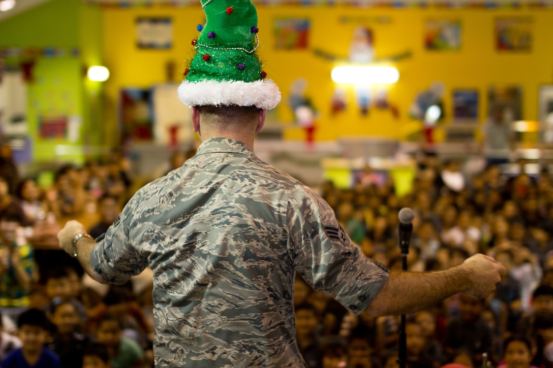 YIGO VILLAGE, Guam -- Senior Airman William Pressgrove, Band of the Pacific-Asia vocalist, dances for students at the Machanano Elementary School, Yigo Village, Guam, Dec. 13, 2011. Pressgrove kept students laughing thoughout the entire show with his antics. (U.S. Air Force photo/Staff Sgt. Josh Voyles)