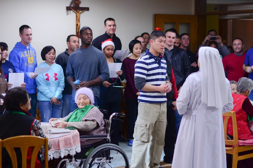 Members of the Wolf Pack sing Christmas carols with residents of the Heart of Jesus Senior Care elderly home during their visit there for a Christmas celebration in Gunsan City, Republic of Korea, Dec. 10, 2011. The senior center was host to many smiles, cake, joint decorating and singing classic Christmas carols. (U.S. Air Force photo by Senior Airman Derrick Schwieters/Released)