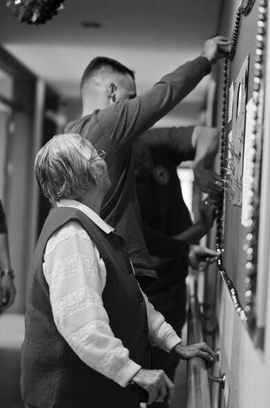 Members of the Wolf Pack assist residents of the Heart of Jesus Senior Care elderly home as they hang Christmas decorations during their visit there for a Christmas celebration in Gunsan City, Republic of Korea, Dec. 10, 2011. The senior center was host to many smiles, cake, joint decorating and singing classic Christmas carols. (U.S. Air Force photo by Senior Airman Derrick Schwieters/Released)