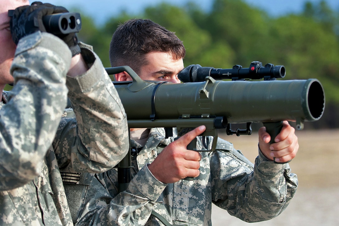 A paratrooper shoulders a Carl Gustav M3 84mm recoilless rifle while his partner optically measures the distance to a target during a certification course on Fort Bragg, N.C., Dec. 6, 2011.