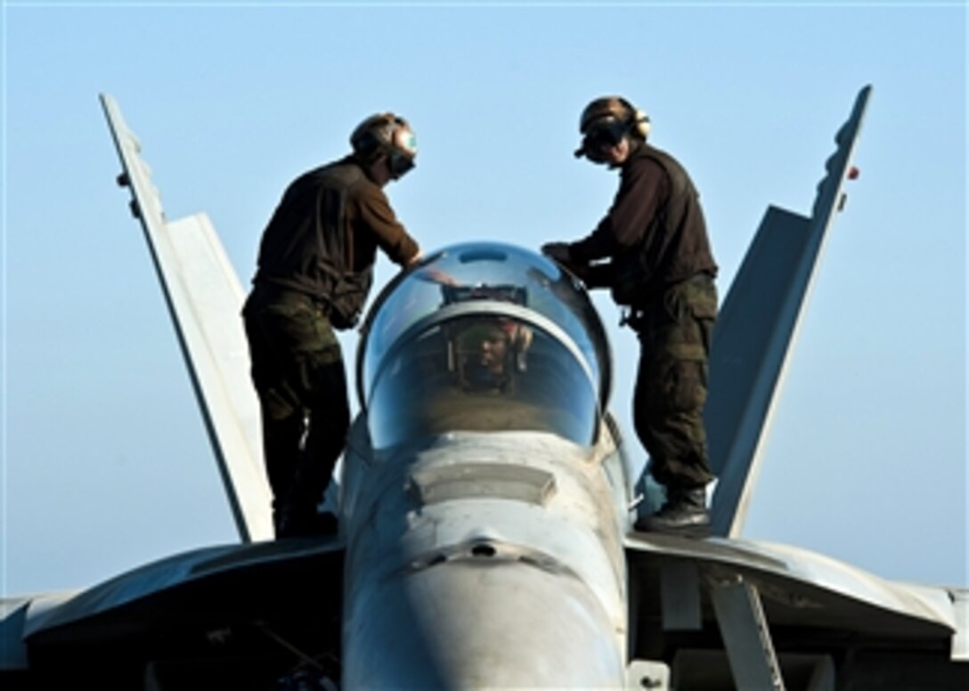 U.S. Navy sailors wipe down the canopy of an F/A-18F Super Hornet aircraft attached to Strike Fighter Squadron 41 aboard the aircraft carrier USS John C. Stennis (CVN 74) while in the Persian Gulf on Dec. 14, 2011.  The John C. Stennis is deployed to the U.S. 5th Fleet area of responsibility conducting maritime security operations and support missions as part of Operations Enduring Freedom and New Dawn.  