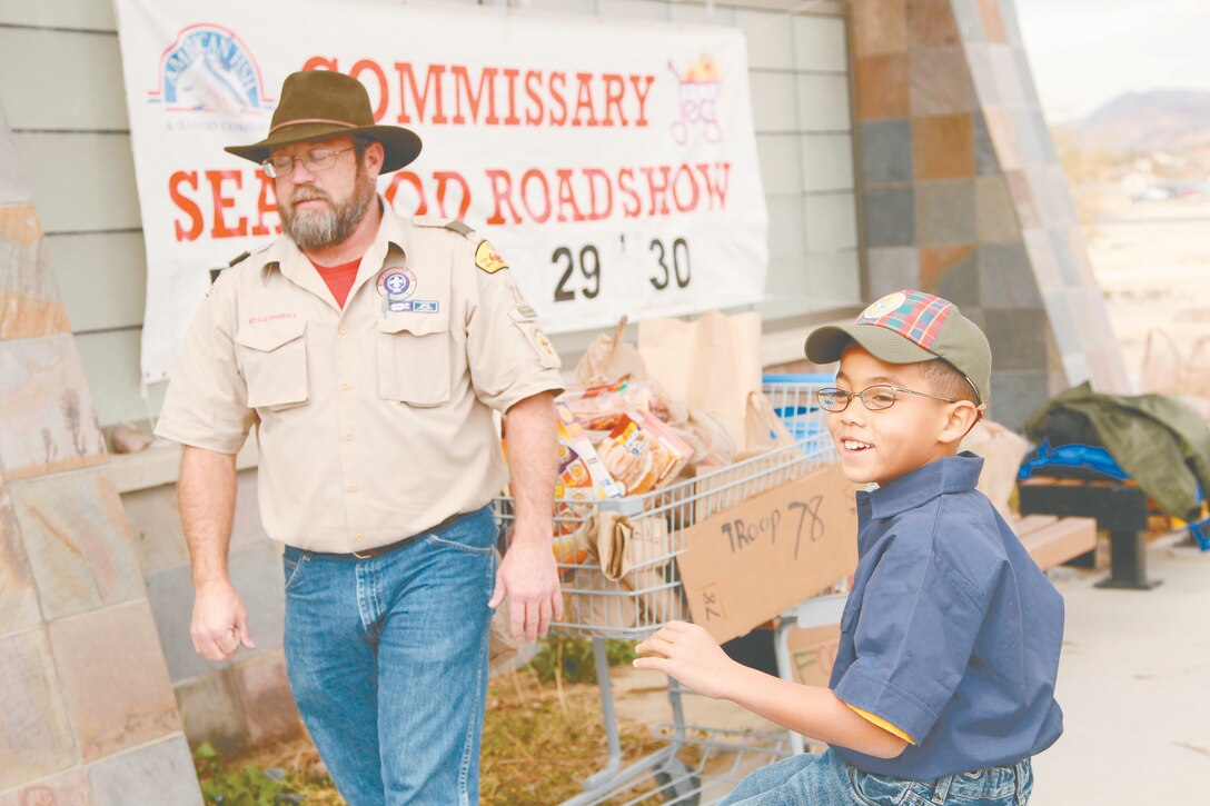 T.K. Shelton, 9, Boy Scout Troop 78, encourages patrons to donate during a food drive outside the Commissary Dec. 17, 2011.